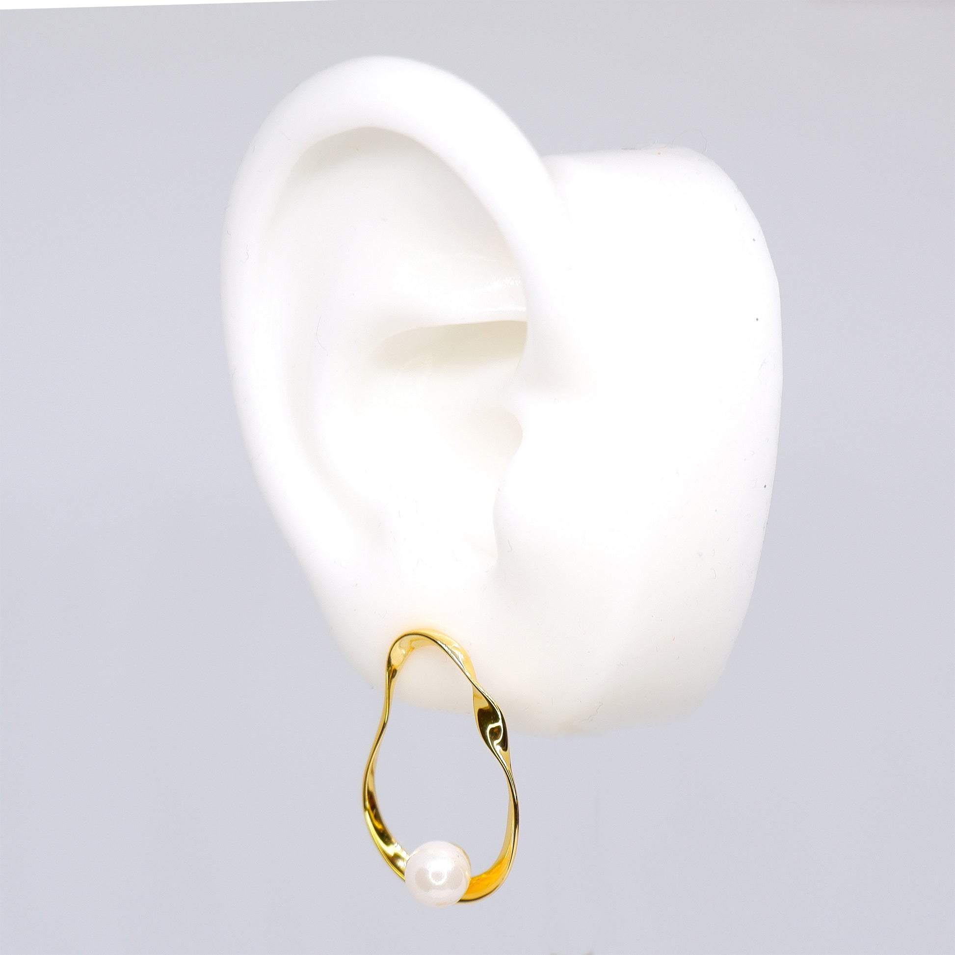 Irregular hoops earrings in 925 sterling silver 18K gold plated with pearls. 